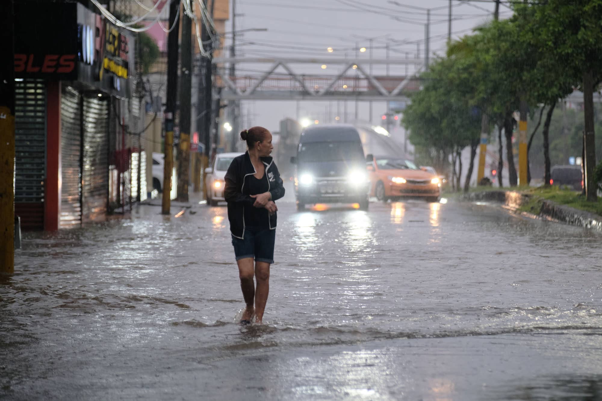 A woman walks in a street flooded by rains caused by Tropical Storm Melissa in Santo Domingo, Dominican Republic, Friday, Oct. 24, 2025. (AP Photo/Ricardo Hernandez)