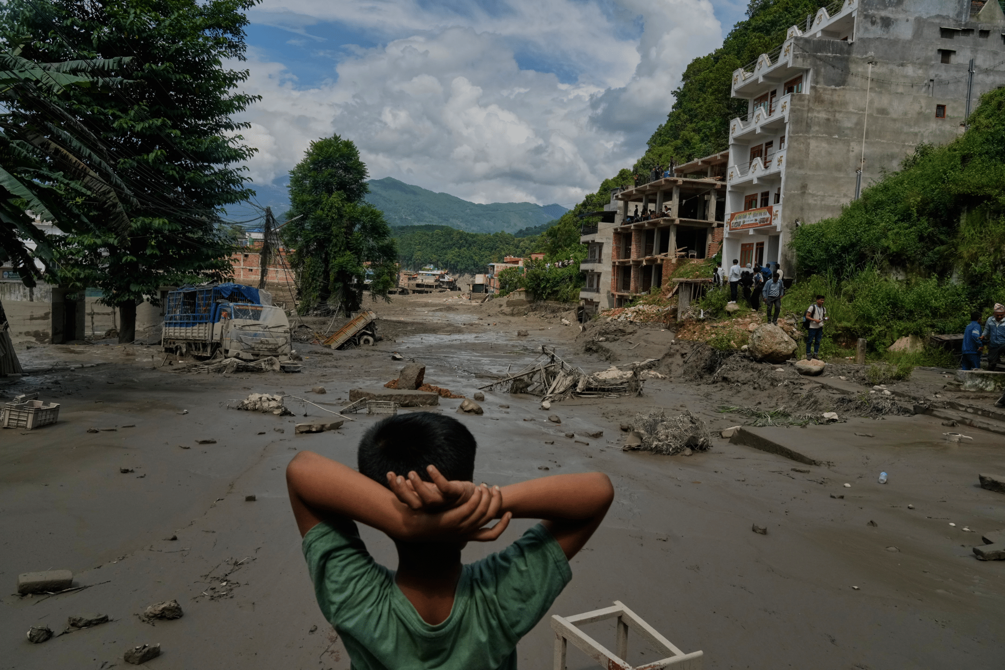A boy looks at the devastation caused by flash flooding along the Trishuli River in Nepal's Nuwakot district, Wednesday, Aug. 26, 2026. (AP Photo/Niranjan Shrestha)
